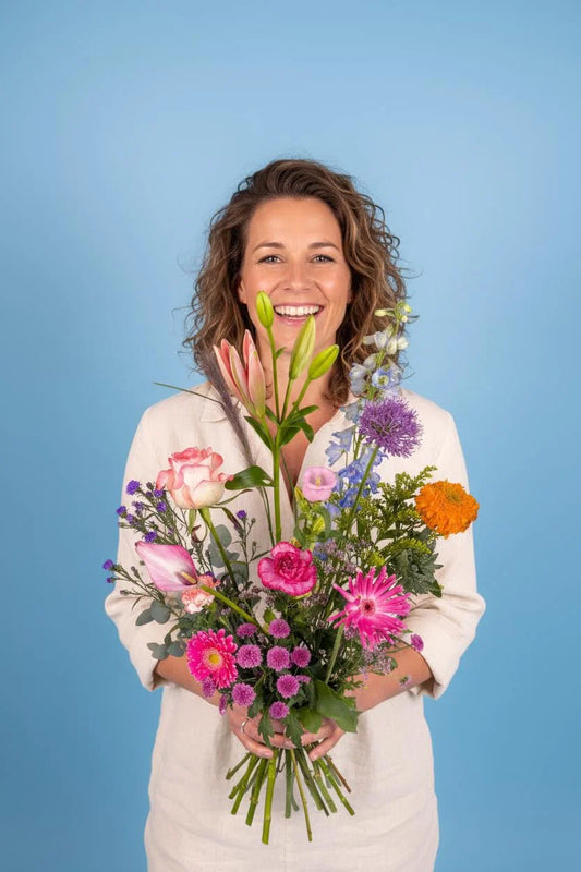 Luxe roze bloemenboeket in transparante vaas, plukvers geleverd voor een warm moment thuis.